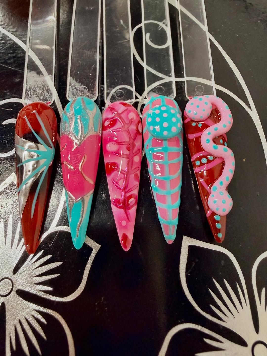 Hand-painted stiletto nail tips on display sticks